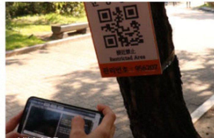마을 골목의 QR 미션 카드를 스캔하는 학생